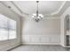 Dining room with decorative molding, chandelier, and large window with natural light at 426 Parkstone Dr, Woodstock, GA 30188