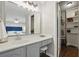 Bathroom vanity with gray cabinets, white countertops, and a view into the bedroom with blue headboard at 603 Dunbar Dr, Dunwoody, GA 30338