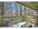 Cozy patio with view of trees, outdoor table and chairs with an area rug on the wooden deck at 603 Dunbar Dr, Dunwoody, GA 30338