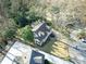 An aerial view of a charming home nestled among mature trees, showcasing its well-maintained roof and manicured lawn at 2953 Hardman Ne Ct, Atlanta, GA 30305