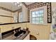 Traditional bathroom with yellow tile and black accents, complemented by decorative floral wallpaper at 2953 Hardman Ne Ct, Atlanta, GA 30305