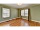 Bedroom with hardwood floors, light green walls, and large windows with curtains at 2953 Hardman Ne Ct, Atlanta, GA 30305