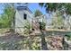 Backyard view of the house, surrounded by greenery, featuring access to a sunroom and a small set of stairs at 2953 Hardman Ne Ct, Atlanta, GA 30305