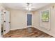 Bright bedroom featuring hardwood floors, ceiling fan, and a window overlooking the property at 3568 Univeter Rd, Canton, GA 30115