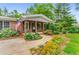 Inviting front porch with a beautiful flower garden and charming details at 3568 Univeter Rd, Canton, GA 30115