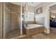 Modern bathroom featuring a glass-enclosed shower and a soaking tub with tiled surround at 4727 Tiger Blvd, Duluth, GA 30096