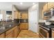 Well-lit kitchen featuring stainless steel appliances, tile backsplash, wooden cabinets, and hardwood floors at 4805 W Village Se Way # 2108, Smyrna, GA 30080