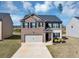 Charming two-story home with a brick and siding exterior, attached two-car garage, and manicured front yard at 1540 Denver Way, Locust Grove, GA 30248