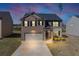 Two-story home features a two car garage, brick and siding exterior, and professionally landscaped front yard at 1540 Denver Way, Locust Grove, GA 30248