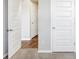 Hallway featuring several white interior doors and wood floors at 1540 Denver Way, Locust Grove, GA 30248