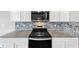 Close-up of stainless steel appliances, granite countertops, and white cabinets in a modern eat-in kitchen at 1540 Denver Way, Locust Grove, GA 30248