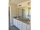 Bright bathroom featuring double sinks, granite countertops, and a large mirror at 480 Brown Dove Ln, Grayson, GA 30017