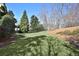 A lush green lawn is surrounded by mature trees and landscaping in this expansive backyard at 11020 Bradford Ln, Suwanee, GA 30024