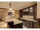 Attractive bar area with stone countertop, dark cabinetry, wine storage, and stainless-steel microwave at 11020 Bradford Ln, Suwanee, GA 30024