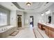 A large bathroom featuring a soaking tub, separate shower and double sink vanity at 11020 Bradford Ln, Suwanee, GA 30024