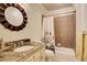 Bathroom with granite countertop vanity, decorative mirror, and shower-tub combination at 11020 Bradford Ln, Suwanee, GA 30024