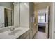 A neutral bathroom vanity connects to a bedroom with chandelier lighting at 11020 Bradford Ln, Suwanee, GA 30024