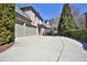 Long concrete driveway leading to a three-car garage and basketball hoop at 11020 Bradford Ln, Suwanee, GA 30024