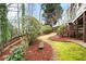 Lush backyard with mature trees and landscaping, bench, and privacy fence at 1207 Woodlawn Ne Dr, Marietta, GA 30068