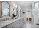 Elegant bathroom featuring double sinks, marble countertops, decorative mirrors, and a glass shower at 1207 Woodlawn Ne Dr, Marietta, GA 30068