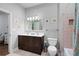 Charming bathroom with a double vanity, framed floral art, and shower with colorful curtain at 1207 Woodlawn Ne Dr, Marietta, GA 30068