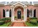 Close-up of a brick home's front door with black shutters and a decorative wreath at 1207 Woodlawn Ne Dr, Marietta, GA 30068