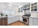 Bright kitchen features white cabinets, marble countertops, stainless steel appliances, and a farmhouse sink at 1207 Woodlawn Ne Dr, Marietta, GA 30068