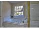 Bright bathroom featuring a white tiled tub under a window and glass enclosed shower at 1326 Nantahala Ne Trl, Marietta, GA 30062