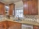 The kitchen features warm wood cabinetry, granite countertops, and a mosaic tile backsplash at 1326 Nantahala Ne Trl, Marietta, GA 30062