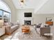 Bright living room with high ceilings, fireplace, and a large window. Staged with modern furniture at 242 Meadow Spring Dr, Temple, GA 30179