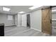 Finished basement area showcasing gray plank flooring and a rustic sliding barn door at 266 Carthage Blvd, Rockmart, GA 30153