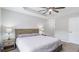Bright bedroom featuring a tray ceiling, neutral walls, ceiling fan, and a bed with a wood headboard at 266 Carthage Blvd, Rockmart, GA 30153