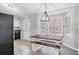 The dining area has a wooden table and white benches, a modern light fixture, and views of the yard at 266 Carthage Blvd, Rockmart, GA 30153