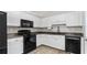 Stylish kitchen boasts white cabinets, dark countertops, and black appliances, offering a modern and sophisticated look at 266 Carthage Blvd, Rockmart, GA 30153