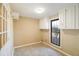 A well-lit laundry room features tiled floors, a window, and white cabinets for optimal storage solutions at 795 Saddle Ridge Trce, Roswell, GA 30076