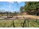 Community playground with swings and slide surrounded by fencing and trees at 795 Saddle Ridge Trce, Roswell, GA 30076