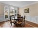 Formal dining room featuring hardwood floors, wainscoting, and arched windows overlooking the front yard at 8116 Powhattan Ct, Mcdonough, GA 30252