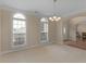 Bright and airy living room with large windows, chandelier, and archway to the adjacent room at 8116 Powhattan Ct, Mcdonough, GA 30252