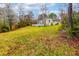 The immense backyard features lush green grass, tall trees, and the in-ground pool at 106 Lanyard Bnd, Peachtree City, GA 30269