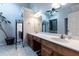 Bright bathroom with double sink vanity, tile floors, and large mirror with decorative plant at 106 Lanyard Bnd, Peachtree City, GA 30269