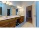 This primary bathroom has double sinks, a large mirror, and views to the walk-in closet and bedroom at 106 Lanyard Bnd, Peachtree City, GA 30269