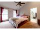 Bright bedroom featuring plush carpet, ceiling fan, and two large windows with vibrant red curtains at 106 Lanyard Bnd, Peachtree City, GA 30269