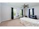 Bright bedroom with neutral carpet has a ceiling fan, two windows, and room for a desk and play area at 106 Lanyard Bnd, Peachtree City, GA 30269