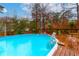 The in-ground pool is surrounded by a wooden deck, privacy fencing, and manicured landscaping at 106 Lanyard Bnd, Peachtree City, GA 30269