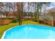 This in-ground pool overlooks the vast backyard with mature trees and green grass at 106 Lanyard Bnd, Peachtree City, GA 30269