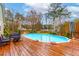 This fenced in-ground pool is surrounded by mature trees and a wooden deck for lounging at 106 Lanyard Bnd, Peachtree City, GA 30269