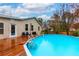 Backyard pool with wooden deck and house exterior view, perfect for summer enjoyment at 106 Lanyard Bnd, Peachtree City, GA 30269