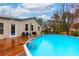 View of the in-ground pool from the wooden deck with the house in the background at 106 Lanyard Bnd, Peachtree City, GA 30269