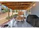 Inviting covered patio featuring a wooden ceiling, a dining table set for six, a barbecue grill, and a cozy fire pit at 108 Rex Ave, Canton, GA 30114
