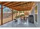 Covered patio featuring wooden beams, concrete flooring, and an outdoor dining area and fire pit at 108 Rex Ave, Canton, GA 30114